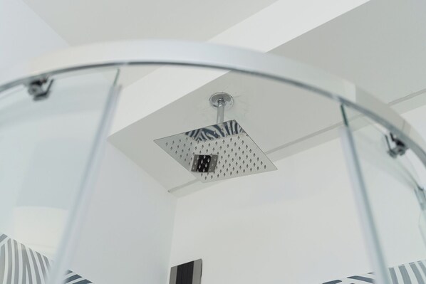 Un baño moderno con cabina de ducha de vidrio y ducha a la vista.