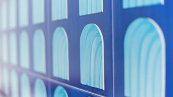 A close-up of a blue wall with multiple arched windows.