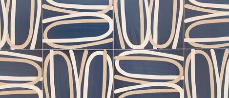 A tiled wall with a repeating pattern of abstract shapes in blue and beige.