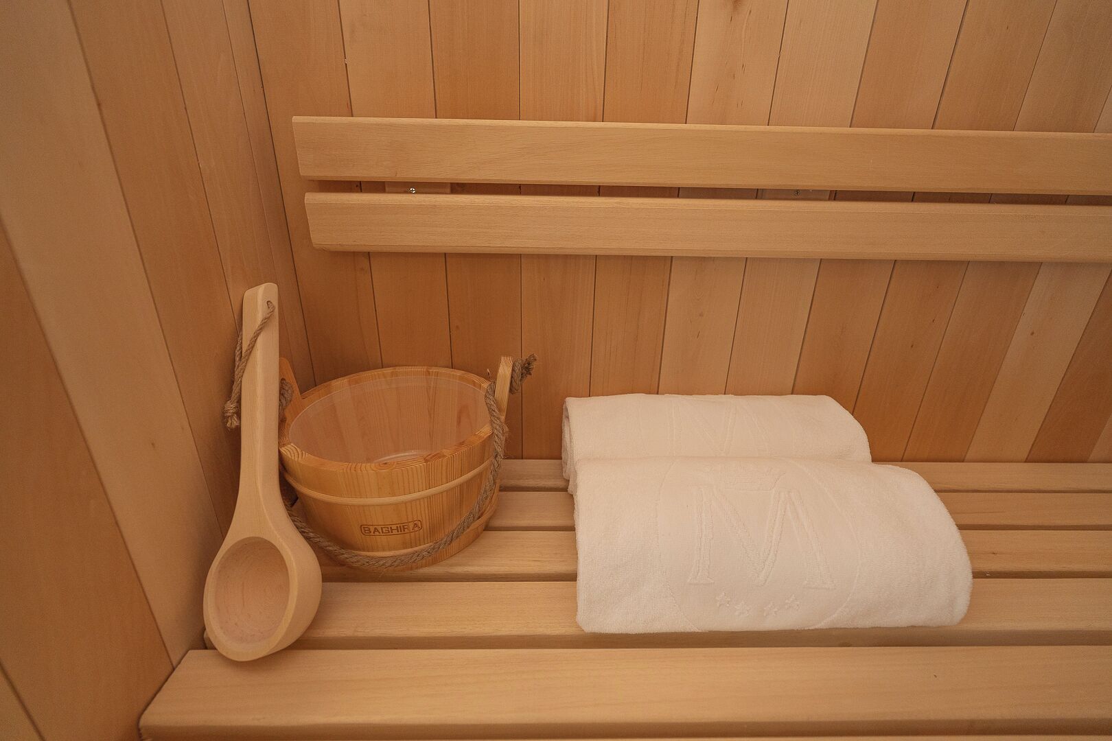 A wooden bench with a wooden basin and a towel.