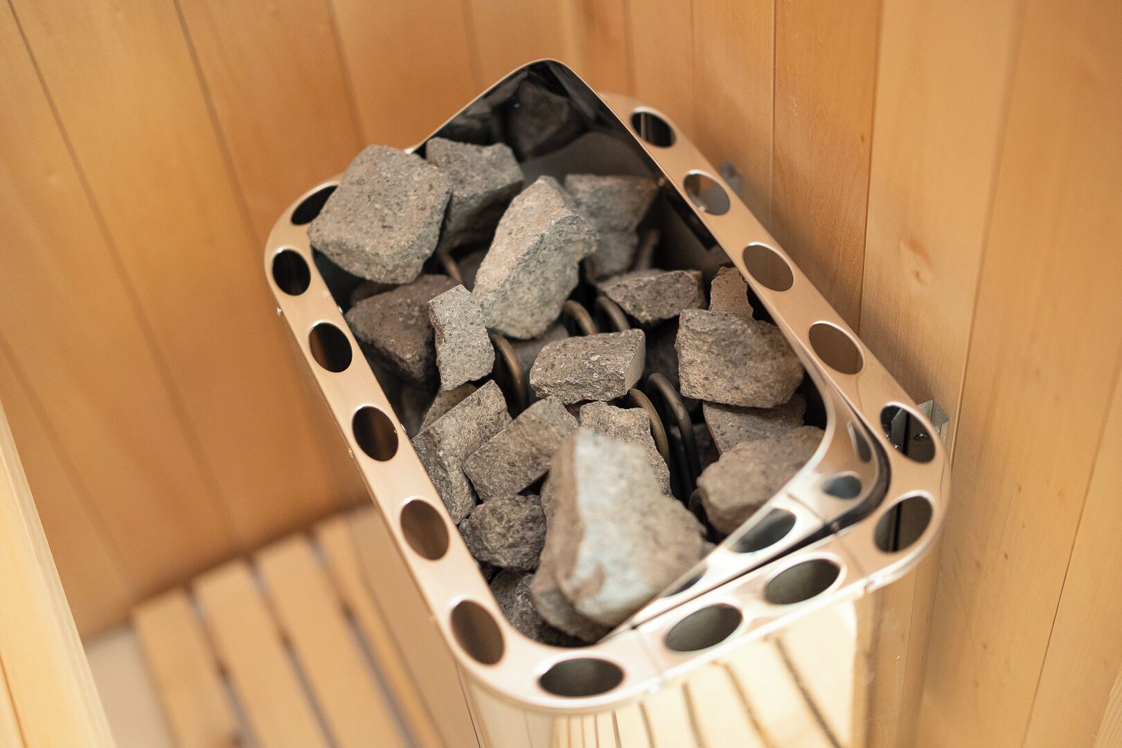 Un recipiente metálico lleno de trozos de carbón vegetal, probablemente para una chimenea.