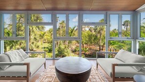A room with large windows, two sofas, and a central coffee table.