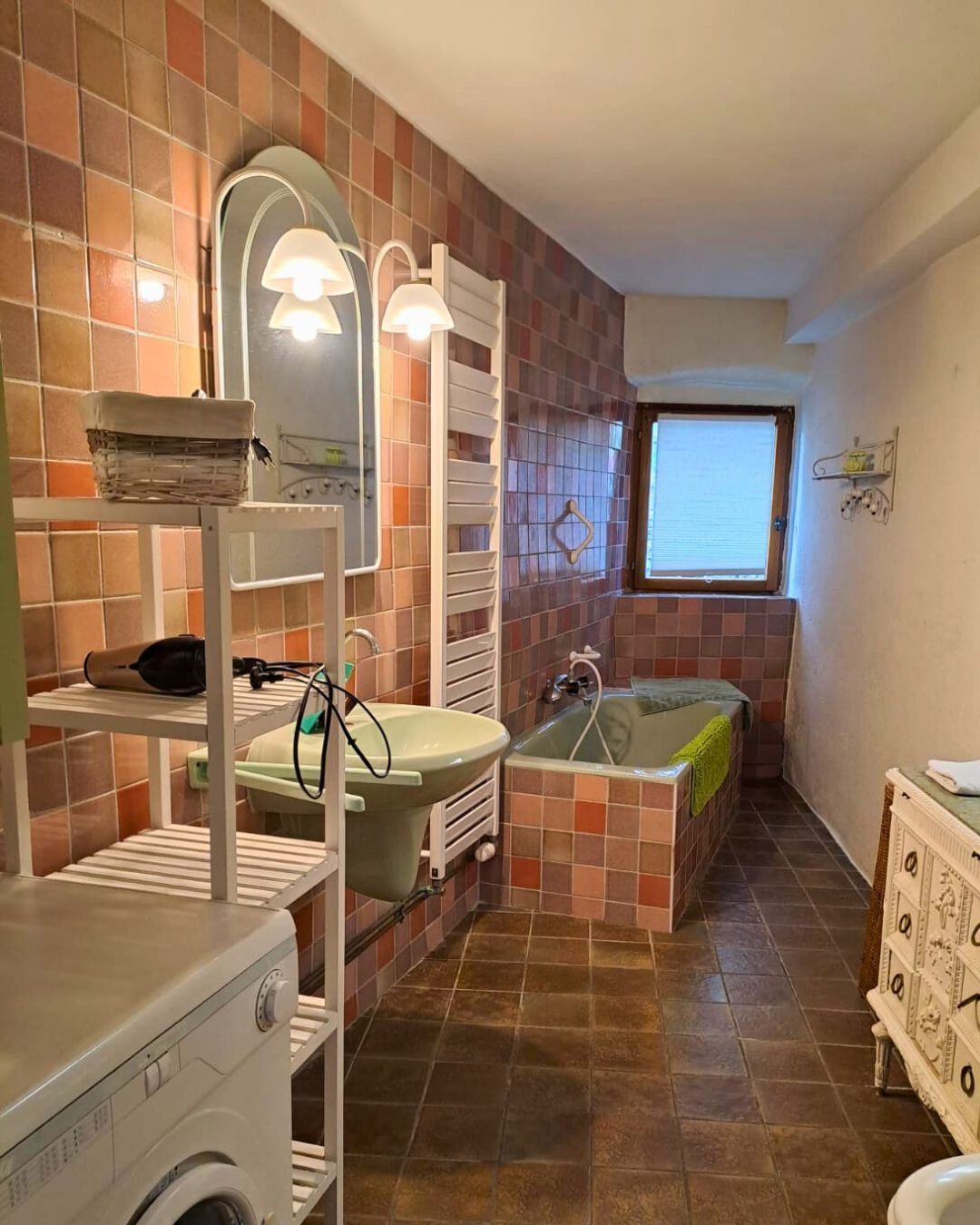 A bathroom with a bathtub, a sink, a mirror, and a window.