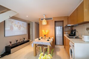 Une cuisine moderne avec des meubles en bois, un four encastré et un lave-linge.