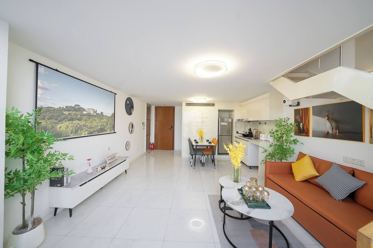 Una sala de estar moderna con un sofá, una mesa de centro y un comedor con sillas y una mesa.
