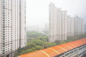 Un ensemble immobilier résidentiel composé d’immeubles de grande hauteur, avec plusieurs bâtiments d’appartements, une gare au toit rouge et une rivière en arrière-plan.