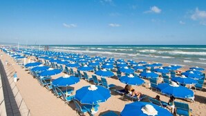 A beach with rows of blue umbrellas and lounge chairs. - Blue Marine Village (Rodi Garganico)