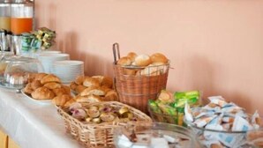A buffet table with various food items and a painting of flowers on the wall. - Blue Marine Village (Rodi Garganico)