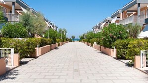 A modern hotel corridor with a central walkway flanked by balconies and greenery. - Blue Marine Village (Rodi Garganico)