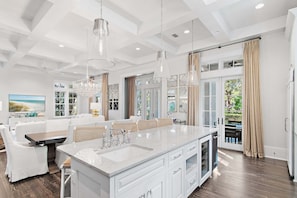A spacious kitchen with a large island, pendant lights, and a view to the outdoors. - WaterColor w Pool, LSV, Carriage House! Gorgeous! (Santa Rosa Beach)
