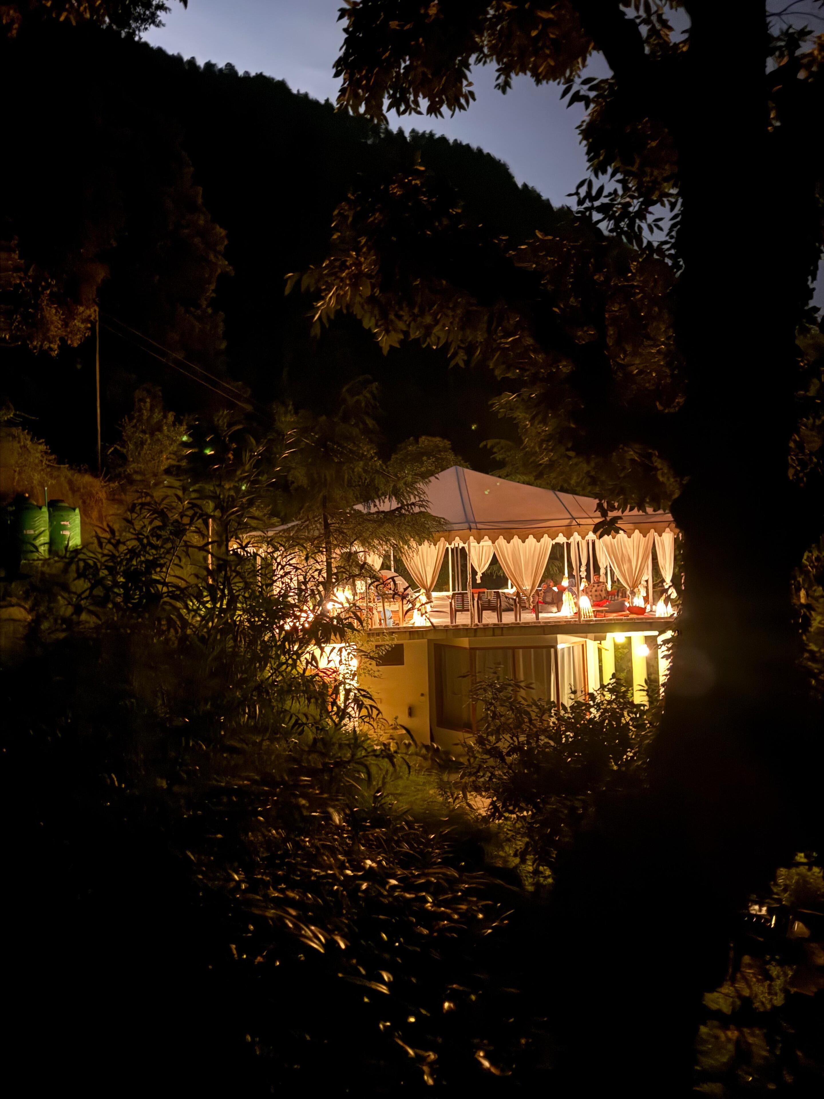Un bâtiment d’un seul étage, bien éclairé, doté d’un patio couvert et entouré d’une végétation luxuriante.