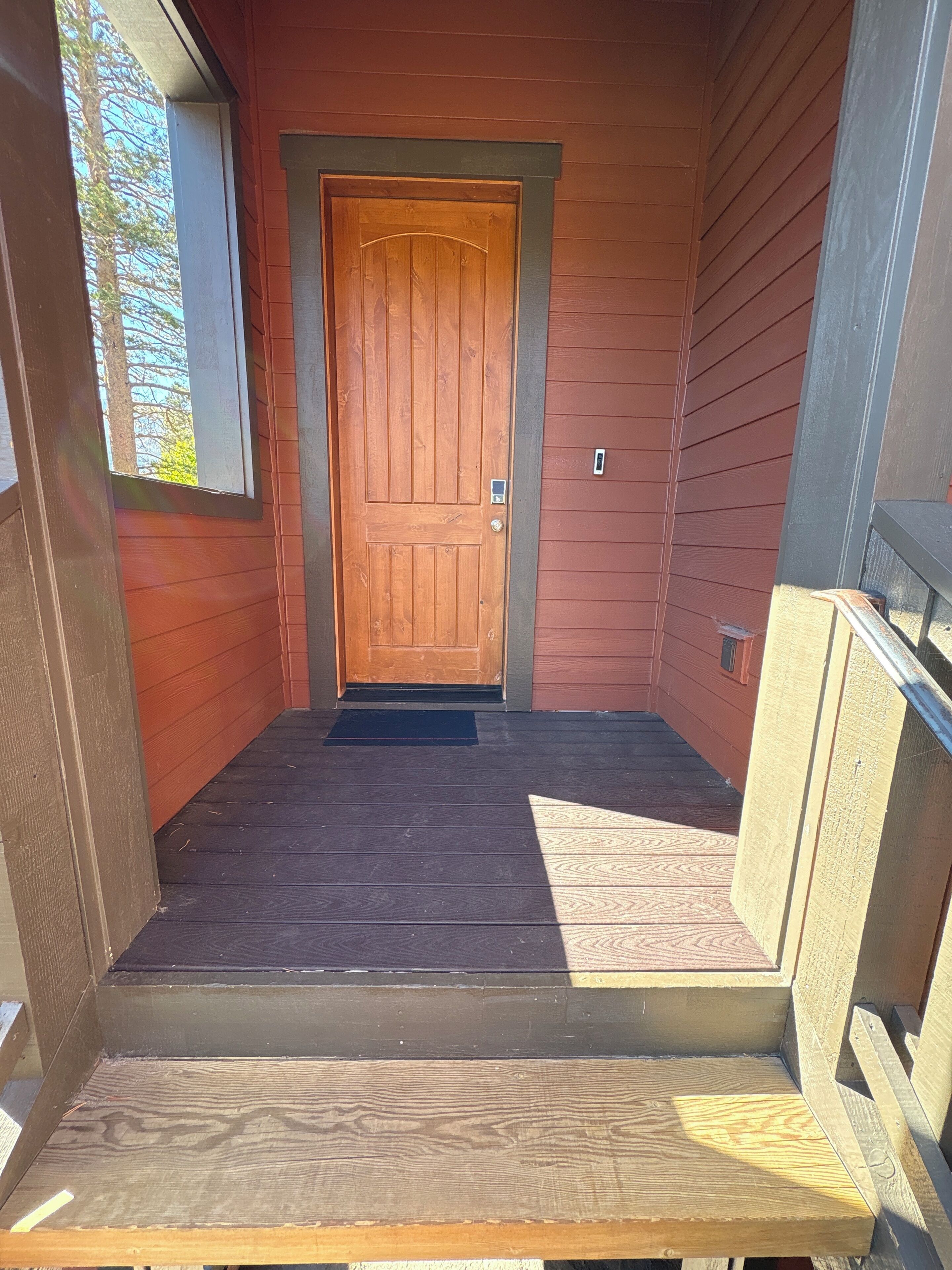A wooden front door with a small porch area.