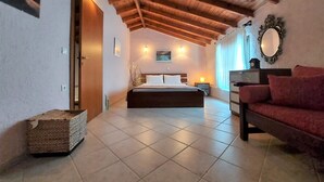 A bedroom with a wooden ceiling, a bed, a nightstand, a red sofa, and a mirror on the wall. - Elani Private Retreat - Villa Anna Garden Escape (Kassandra)