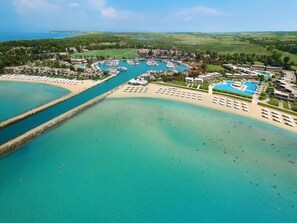 An aerial view of a coastal resort with a marina, beach, and swimming pool. - Elani Private Retreat - Villa Anna Garden Escape (Kassandra)