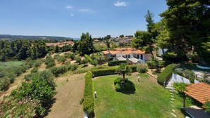 A residential area with houses, a well-maintained garden, and a clear view of the surrounding landscape. - Elani Private Retreat - Villa Anna Garden Escape (Kassandra)