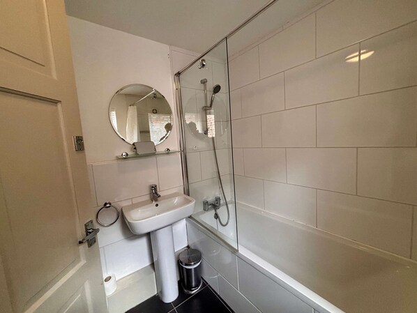 A bathroom with a sink, mirror, and shower. - St Denys View With Free Parking (York)