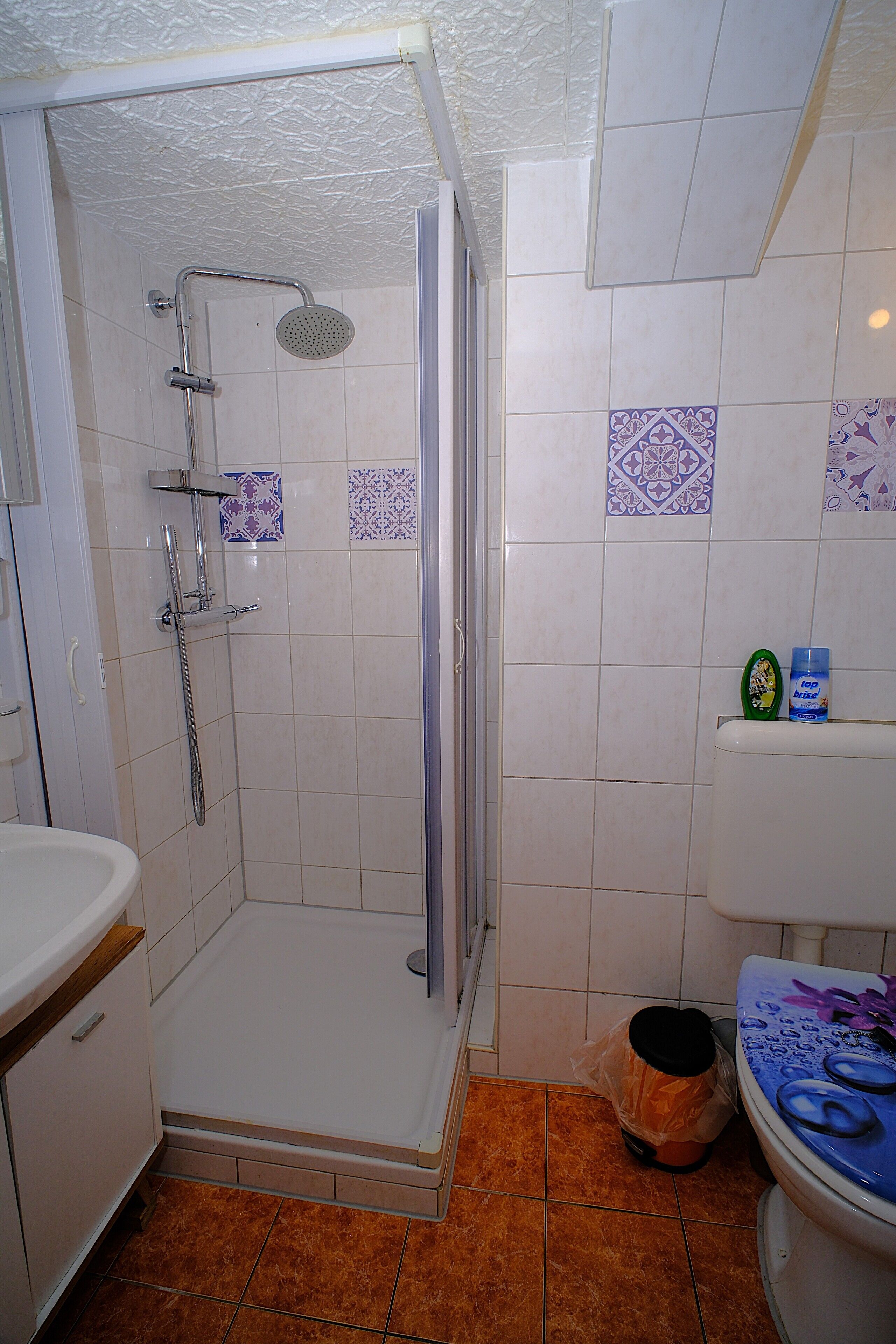 A bathroom with a shower, toilet, and sink.