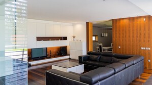 Een moderne woonkamer met een modulaire bank, een flatscreen televisie en een houten accentmuur.
