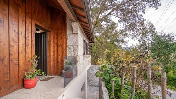 Une façade en bois, un mur en pierre et une clôture en bois.