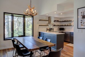 A modern kitchen with a central island, black chairs, and a chandelier. - Condo 3B/3BA + Amenity Pass w/ Hot Tub + Pool. (Blowing Rock)