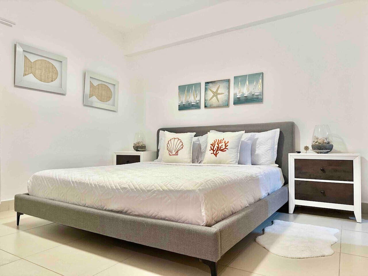 A bedroom with a bed, nightstands, and decorative wall art.