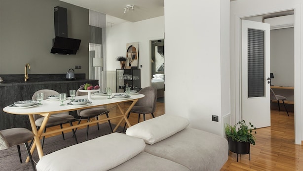 A modern living space with a dining area, a sofa, and a kitchen. - Anvy Stylish Suites Ioannina (Ioannina)