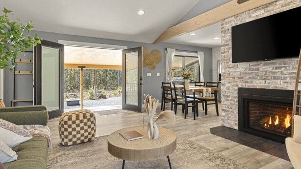 A modern living room with a fireplace, a dining area, and a large window overlooking a garden. - Beautiful Nature Retreat minutes to Mt. Rainier (Elbe)