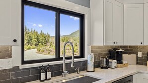 A modern kitchen with a large window, a stainless steel sink, and a coffee maker. - Beautiful Nature Retreat minutes to Mt. Rainier (Elbe)