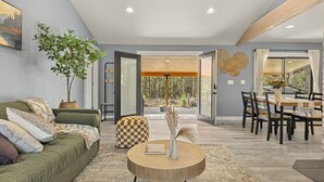 A modern living room with a green sofa, a round wooden coffee table, and a dining area with a wooden table and chairs. - Beautiful Nature Retreat minutes to Mt. Rainier (Elbe)