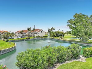 A residential area with a swimming pool, houses, and a fountain.