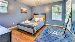 A bedroom with a bed, a ceiling fan, a window, and a rug with a geometric pattern. - 4 Mi to Dtwn Jacksonville: Game Day Escape! (Jacksonville)