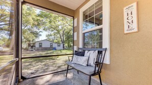 A porch with a bench, a 'Welcome to our HOME' sign, and a view of a house and trees. - 4 Mi to Dtwn Jacksonville: Game Day Escape! (Jacksonville)