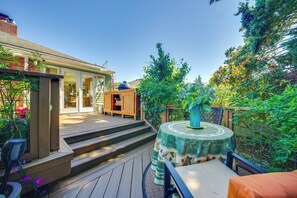 A wooden deck with a table and chairs, a barbecue grill, and a house in the background. - 6 Mi to Dtwn Seattle: Walkable Home w/ Hot Tub (Seattle)