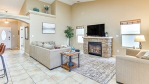 Una sala de estar con chimenea, televisor y sofá.