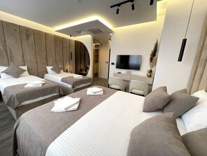 A modern hotel room with two beds, a TV, and a desk. - Hotel NPL CODE (East Sarajevo)