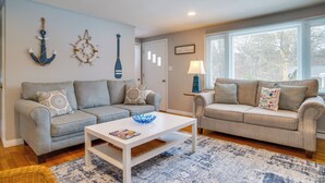 A living room with two grey sofas, a white coffee table, and nautical-themed wall decorations. - < 1 Mi to Craigville Beach: Home w/ Patio & BBQ (Centerville)