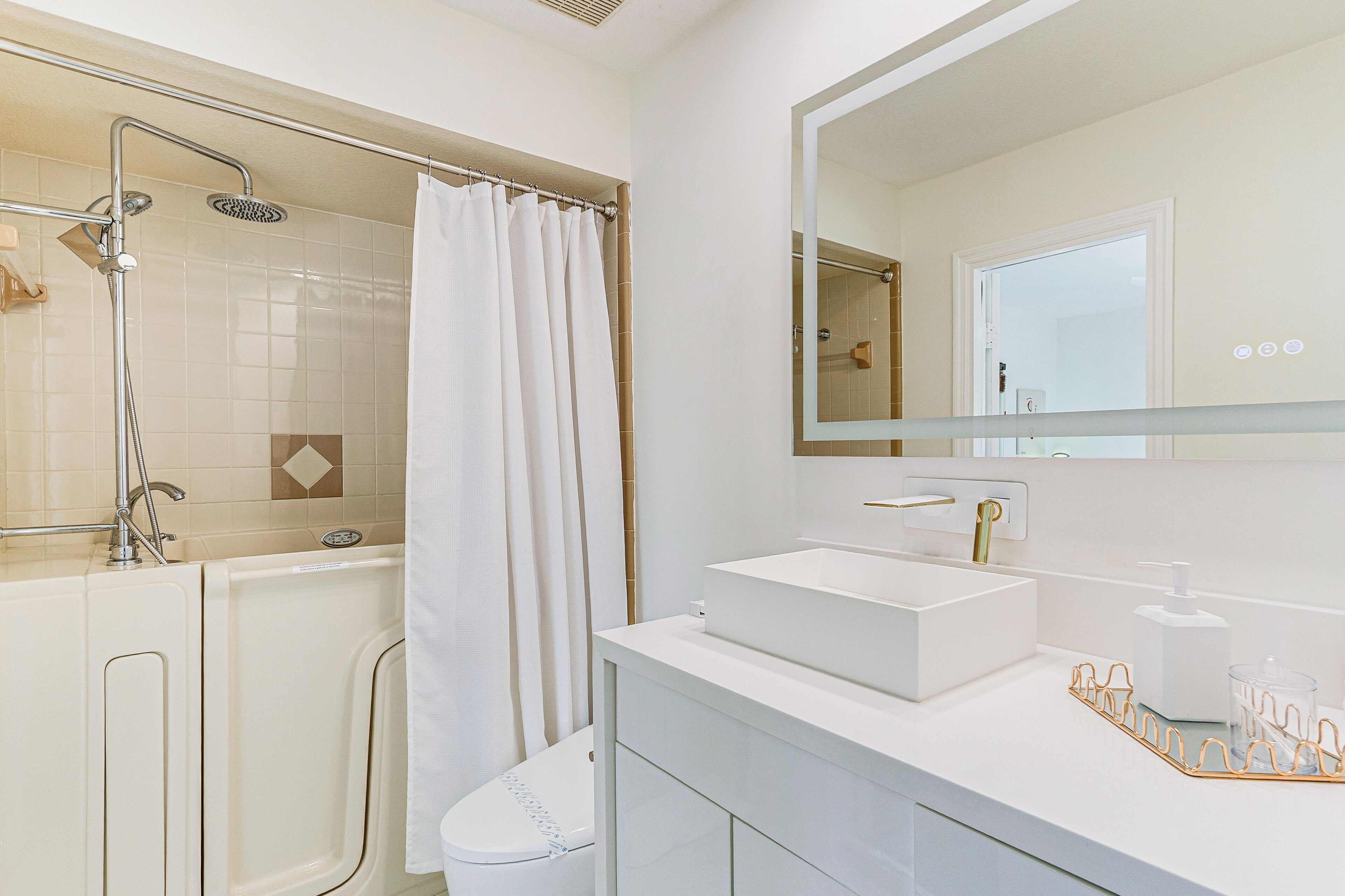 A modern bathroom with a shower, toilet, and sink.