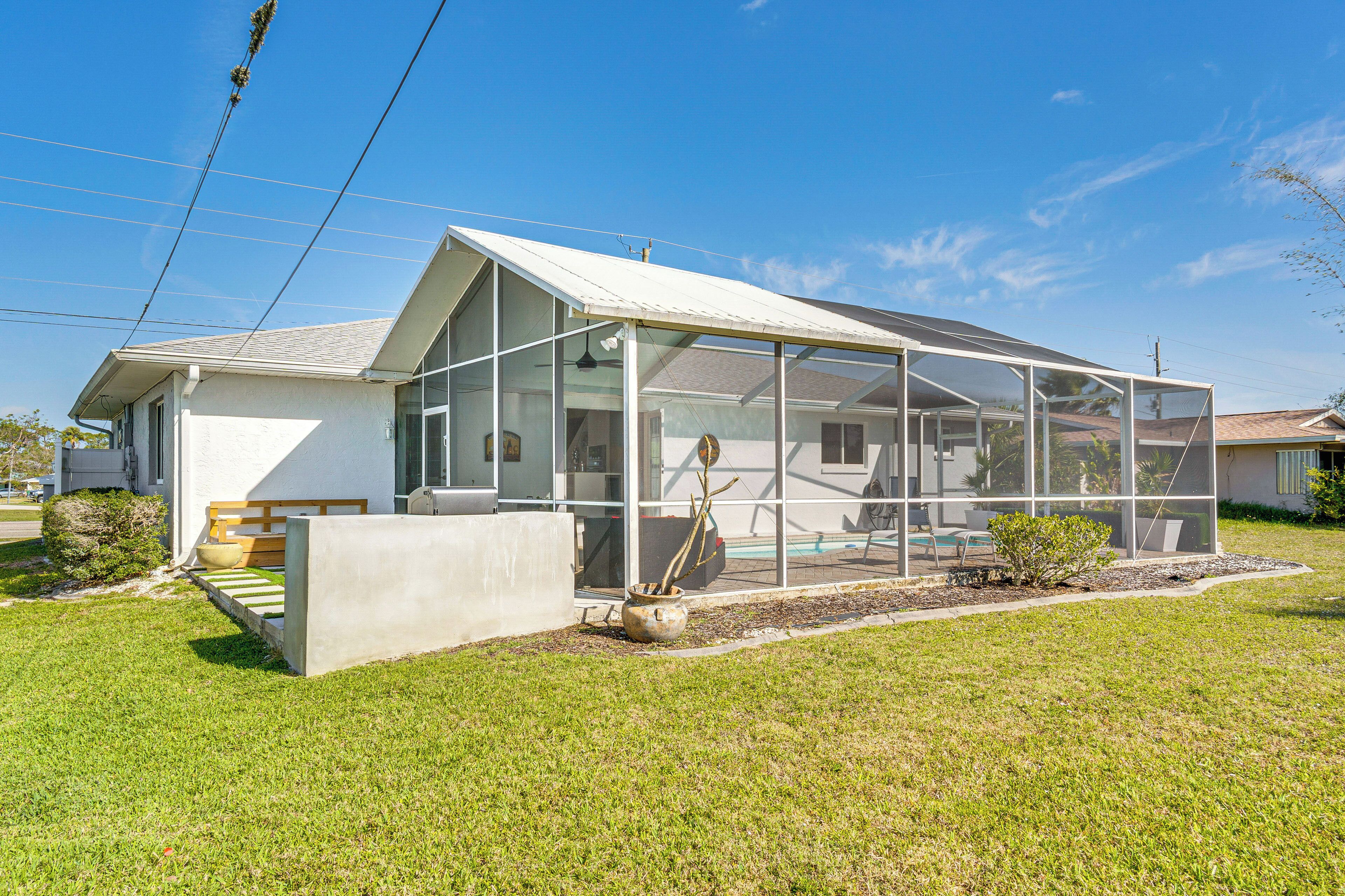 A modern house with a large glass extension, a concrete bench, and a small garden area.