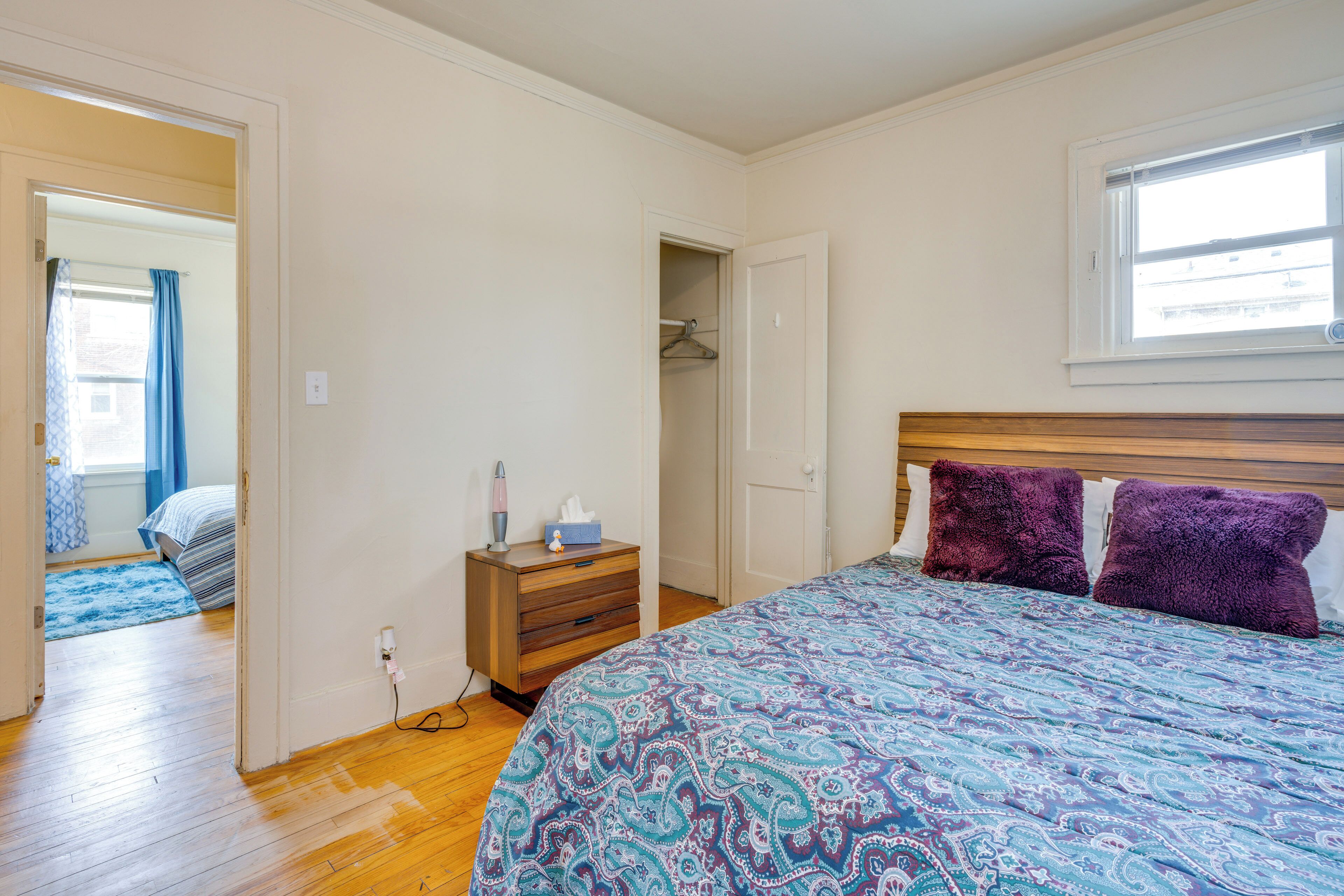 Une chambre à coucher avec un lit, une commode, un placard et une fenêtre.