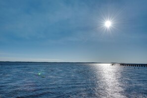 A pier extending into calm waters under a clear sky.