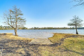 A lakeside path leading to a body of water with trees on either side.
