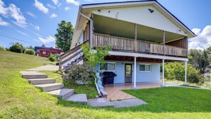 Een twee verdiepingen tellend huis met een balkon, een voortuin en een kleine voortuin met treden die naar de ingang leiden.