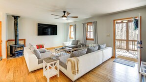 A modern living room with a sofa, coffee table, and a fireplace. - Deer River Retreat: Cabin Feel w/ Modern Touches (Sparta)
