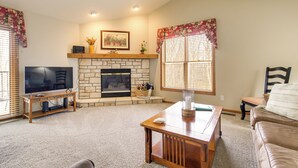 A living room with a fireplace, television, and comfortable seating. - 'rise and Shine in Door County!' Egg Harbor Haven (Egg Harbor)