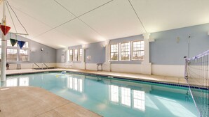 An indoor swimming pool with clear blue water, a diving board, and a netted area for safety. - 'rise and Shine in Door County!' Egg Harbor Haven (Egg Harbor)