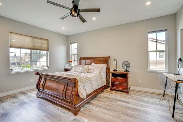 A bedroom with a wooden bed, a desk, and a chair.