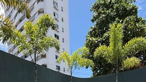 A swimming pool with clear water, surrounded by lounge chairs and tropical plants. - Urban - Ed. Luciene (Recife)