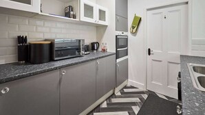 Eine kleine Küche mit Mikrowelle, Toaster und Backofen.