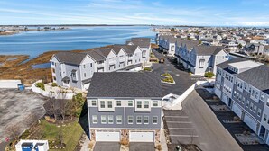 Un quartier résidentiel avec des maisons, un parking et une étendue d’eau en arrière-plan.