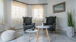 Une pièce comprenant deux fauteuils, une petite table ronde, un vase décoratif et une plante en pot.